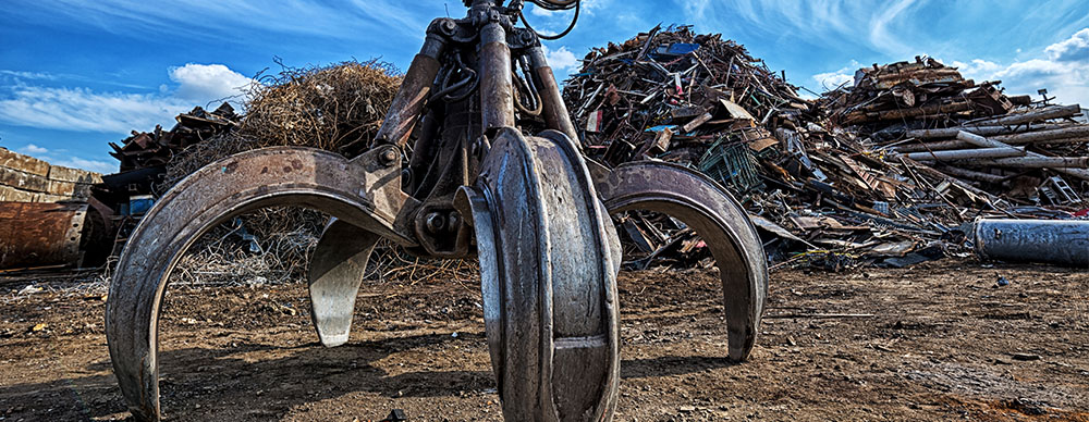 Claw digging into the ground at a recycling plant