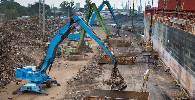 Cranes move materials at a recycling facility